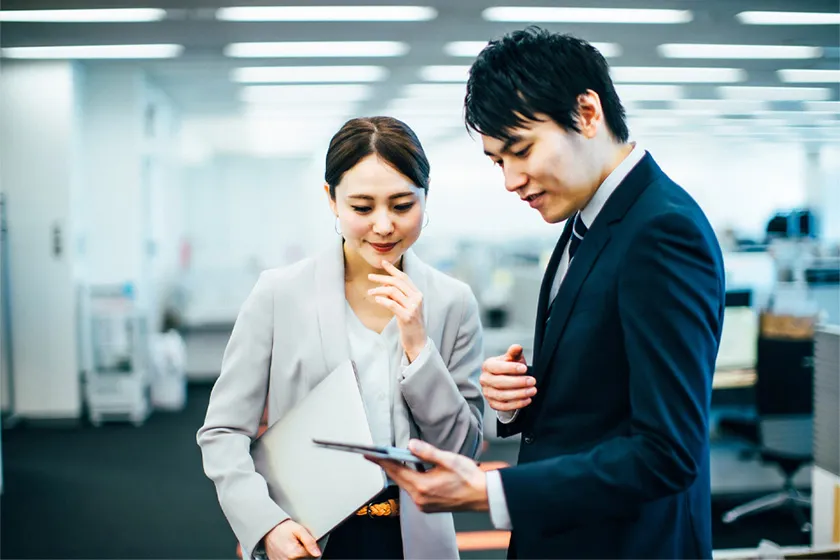 ふたりの社員が電卓を見ながら話している写真