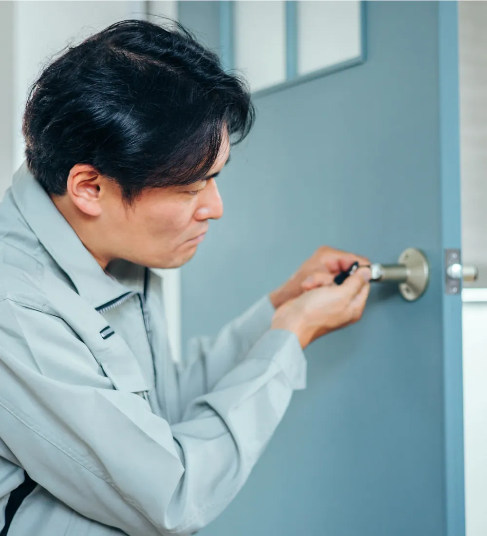 箒と塵取りを持って清掃中の作業員の後ろ姿の写真
